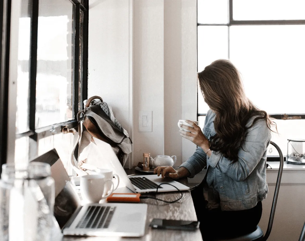 Eine Person, die einen Kaffee genießt, während sie ihren Urlaub mit Inallow plant